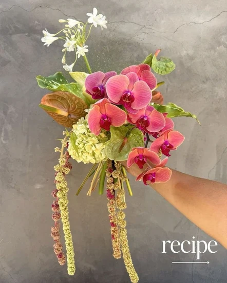 Vibrant pink orchids and trailing yellow flowers in the Kiwi bouquet