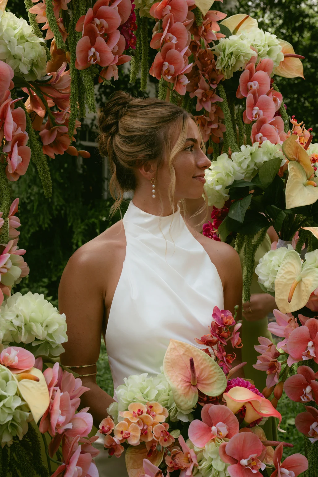 Kiwi, the creative behind Kiwi Curates, among colorful orchids